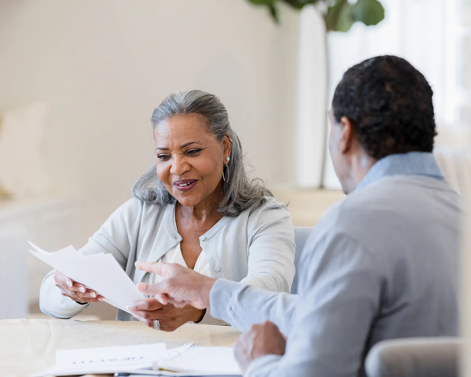Elderly pair examining financial papers indoors