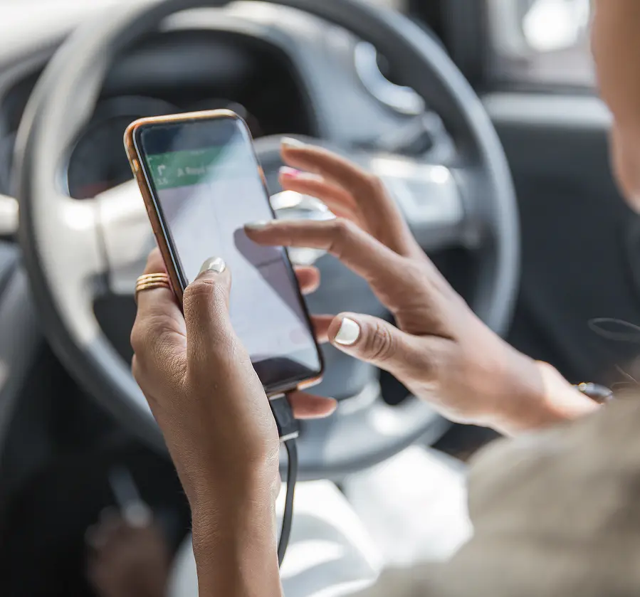 Person using smartphone in car