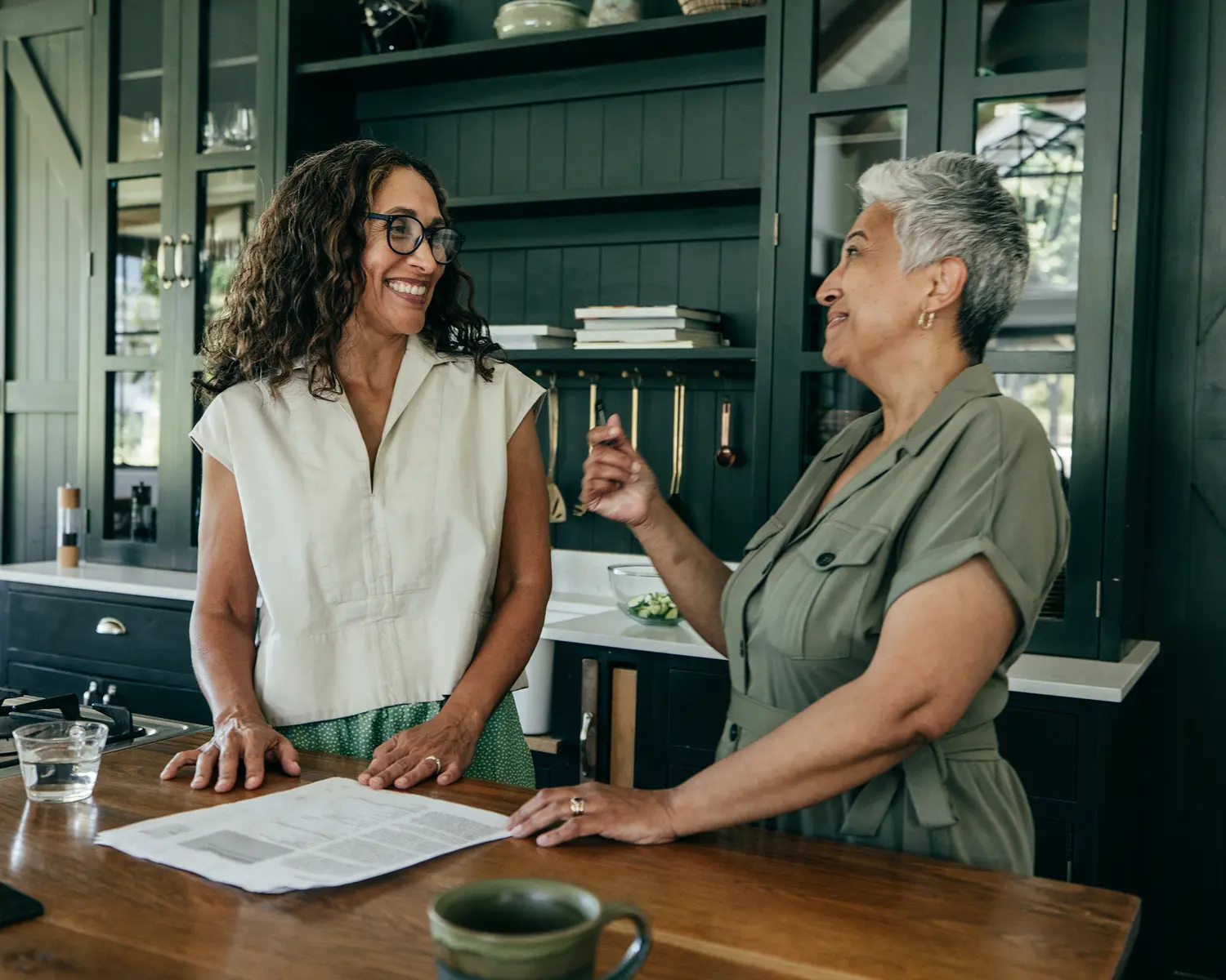 Women smiling and talking in modern kitchen