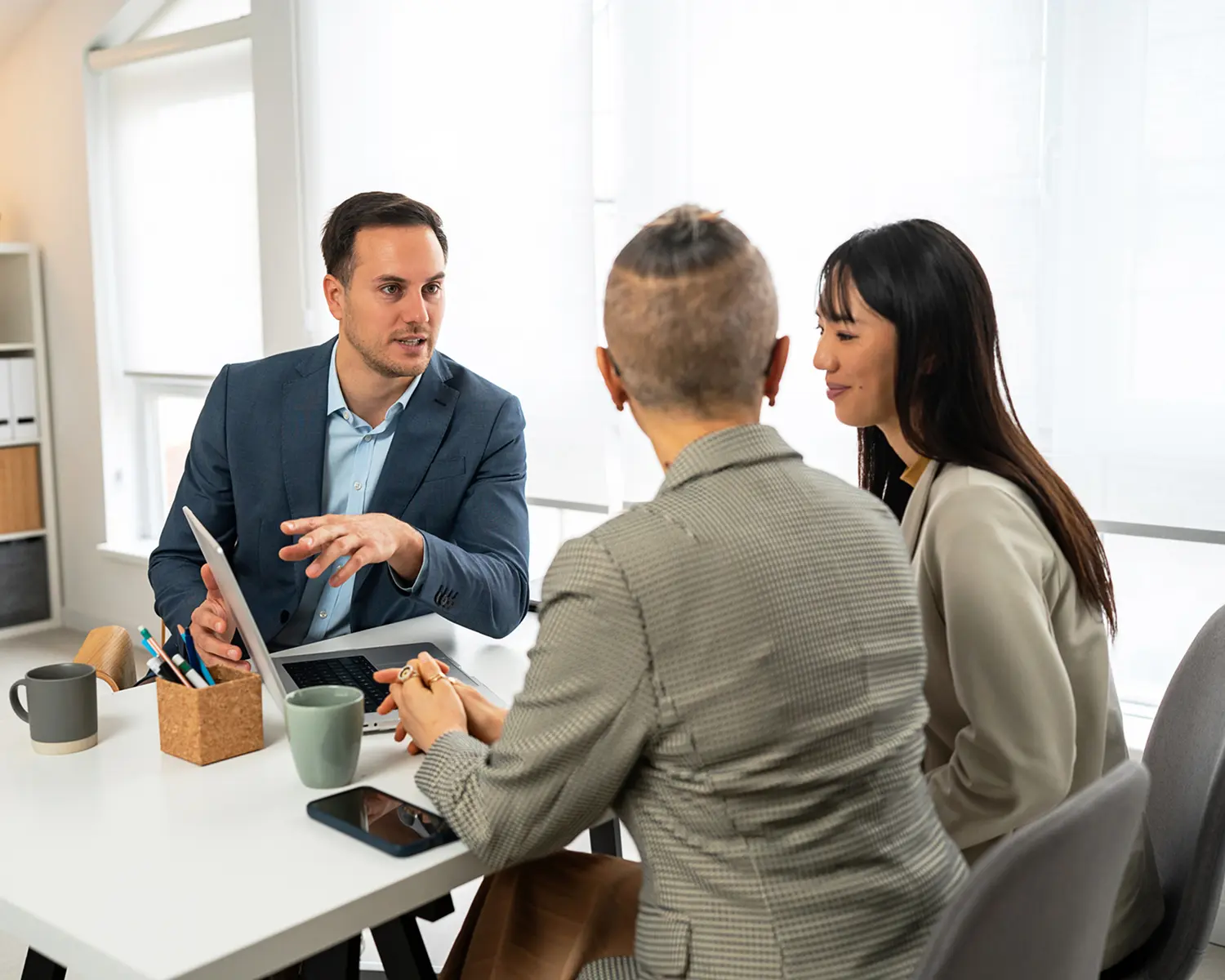Three colleagues collaborating in modern workspace