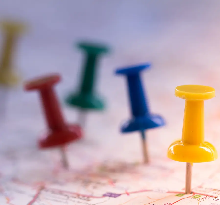 Assorted pushpins on geographic map